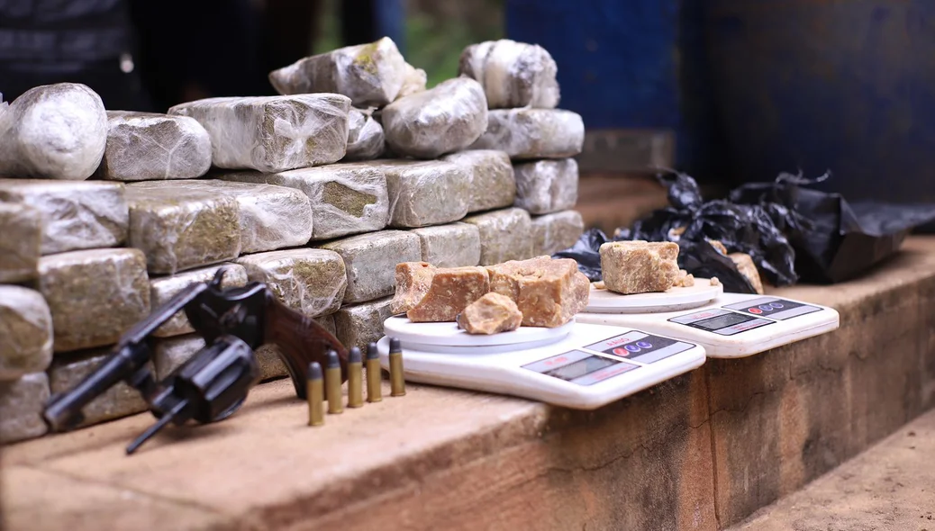 Várias balanças de precisão e duas armas de fogo apreendidas