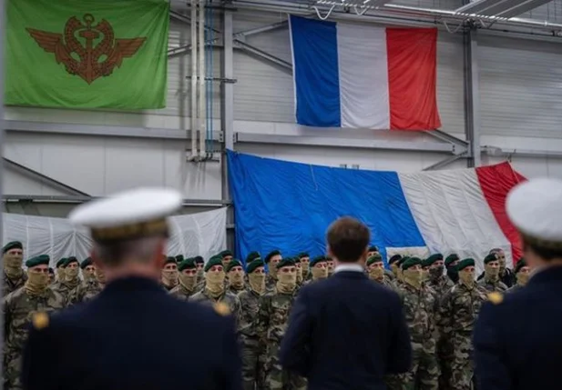 Presidente Emmanuel Macron em frente à bandeira da França
