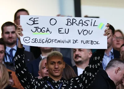 Richarlison com o cartaz de apoio à seleção brasileira de futebol feminino