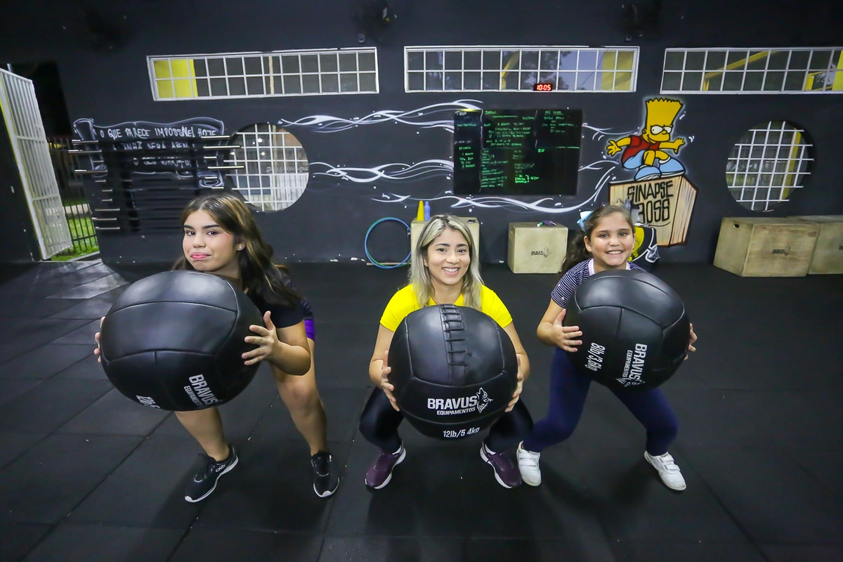 Filhas acompanham a mãe nos exercícios do crossfit
