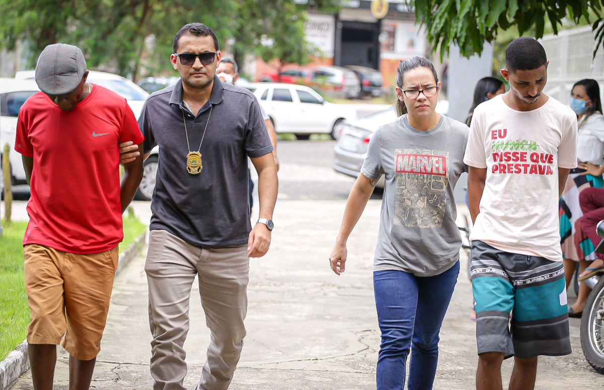 Francisco de Assis Nunes da Silva, na ponta esquerda, e Ítalo Rangel Santos dos Reis na ponta direita sendo conduzidos por policiais do DHPP