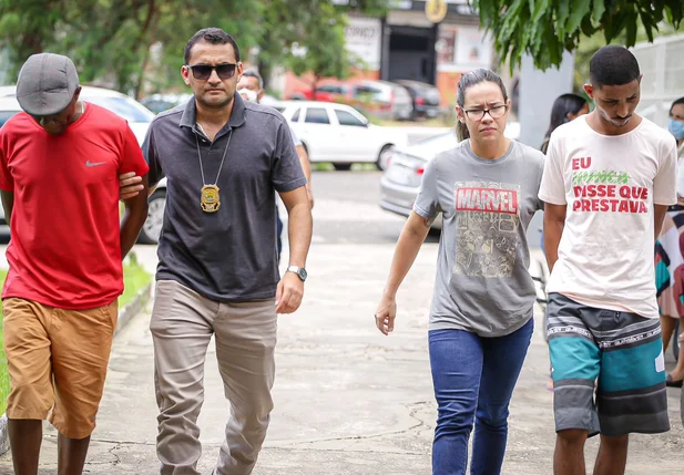 Francisco de Assis Nunes da Silva, na ponta esquerda, e Ítalo Rangel Santos dos Reis na ponta direita sendo conduzidos por policiais do DHPP