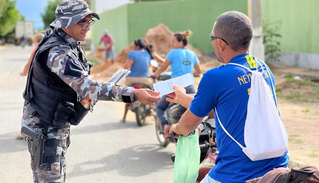 PM entregando panfleto à população em conscientização da campanha Maio Amarelo