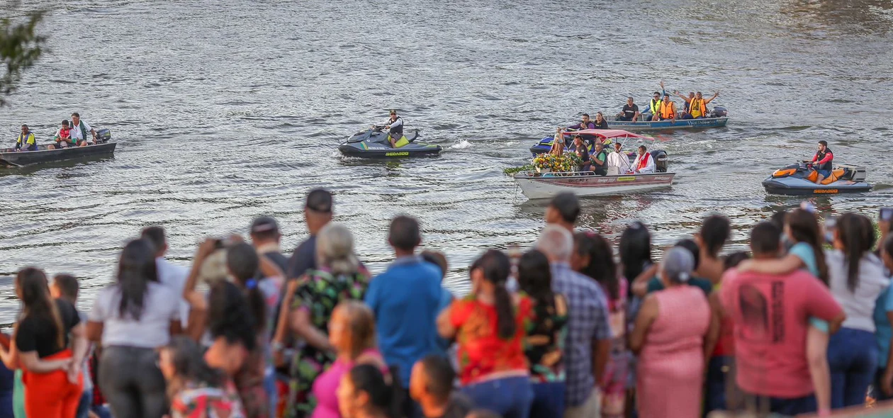 Fiéis na beira do rio aguardam a chegada da imagem do santo