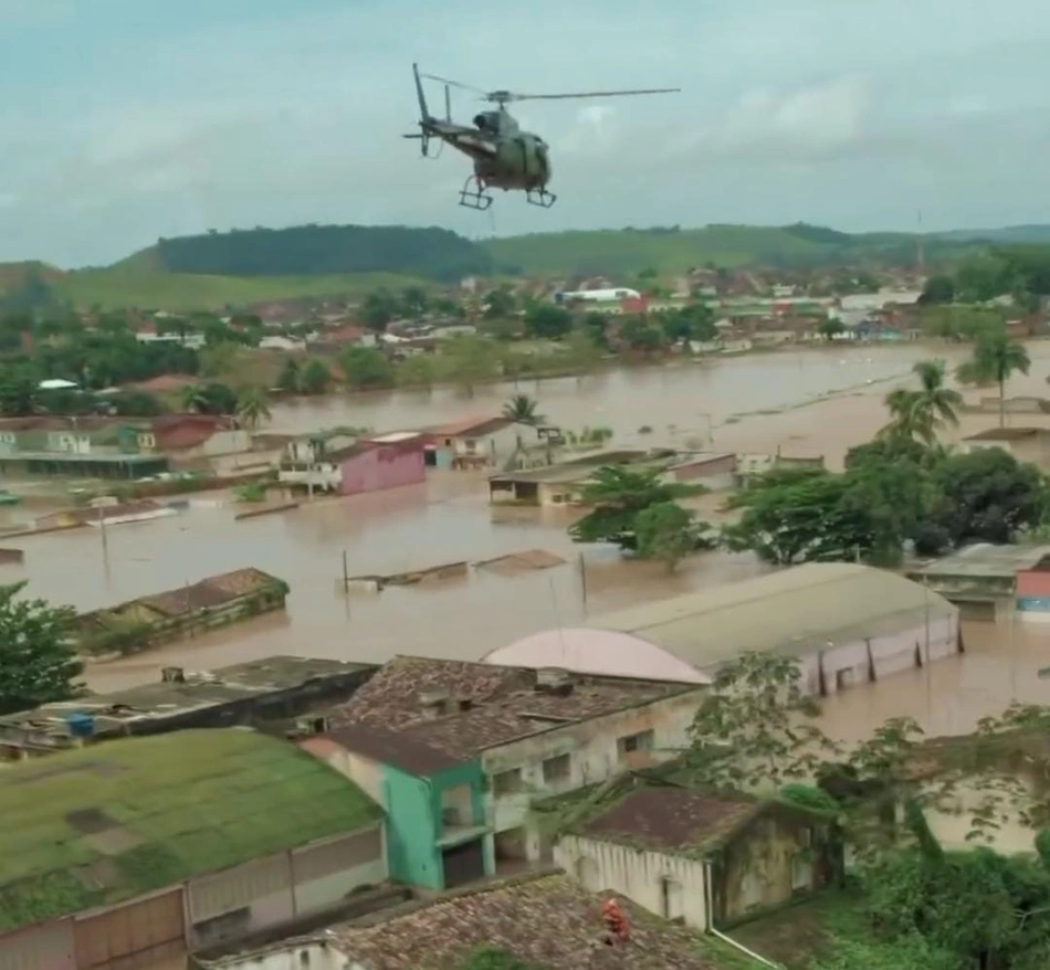 Equipe do Corpo de Bombeiros Militar de Alagoas em helicóptero durante ações de resgate em área bastante comprometida
