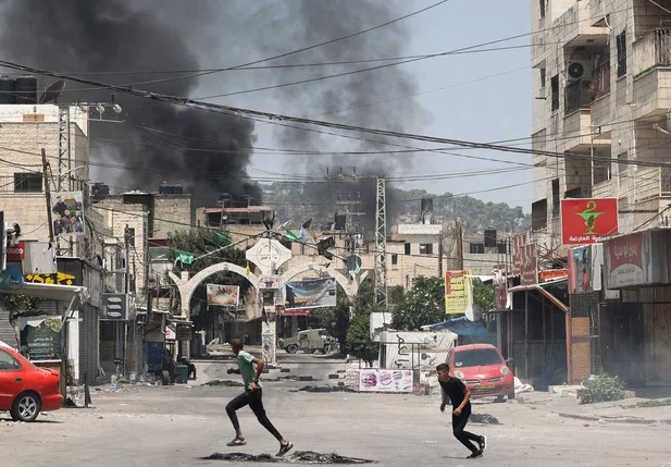 Palestinos correm durante ação militar israelense em Jenin, na Cisjordânia