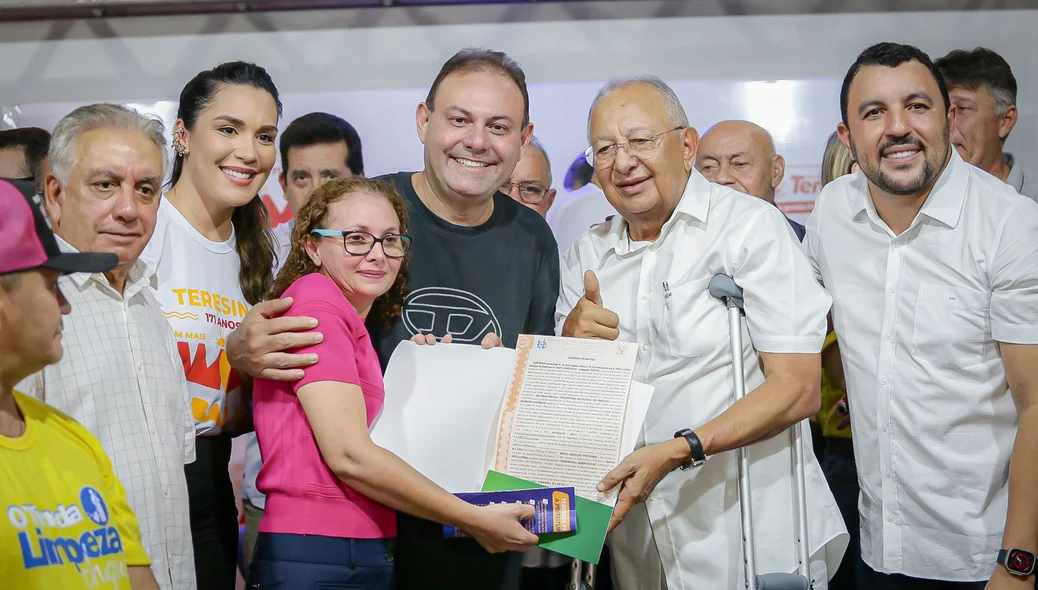 Moradora recebendo o registro de imóvel