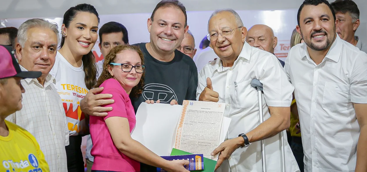 Moradora recebendo o registro de imóvel