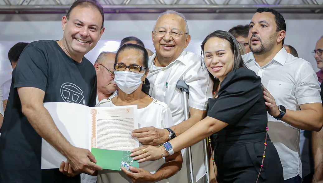 Moradora recebendo o seu registro de imóvel