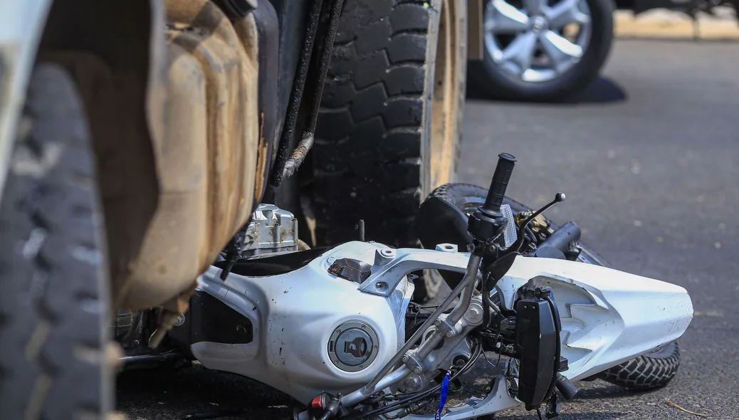 Motocicleta ficou destruída debaixo do caminhão