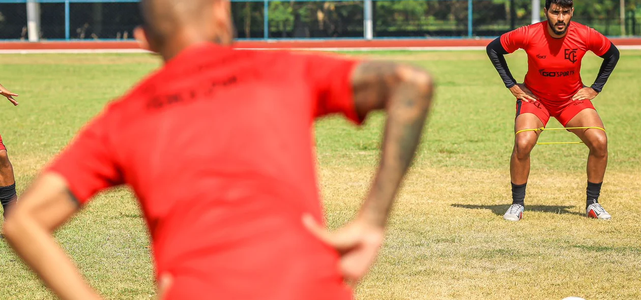 Atletas se alongam antes do treino