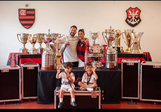 Everton Ribeiro e sua família ao lado das 11 taças conquistas em sete anos