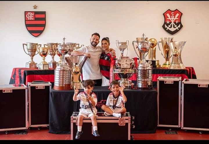 Everton Ribeiro e sua família ao lado das 11 taças conquistas em sete anos