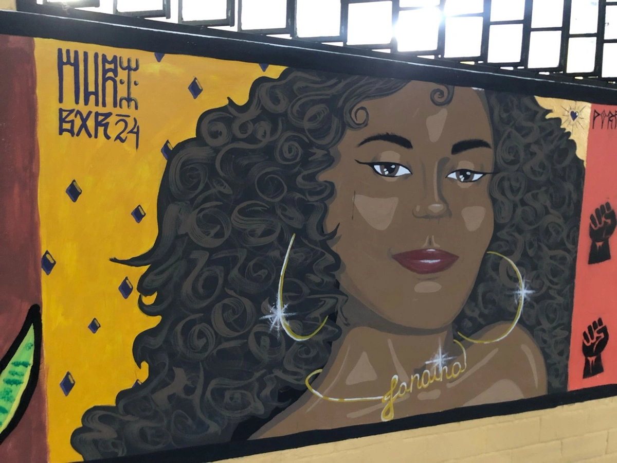 Imagens de Janaína Bezerra pintada em um mural do DCE