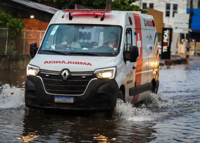 Ambulância transitando na via alagada