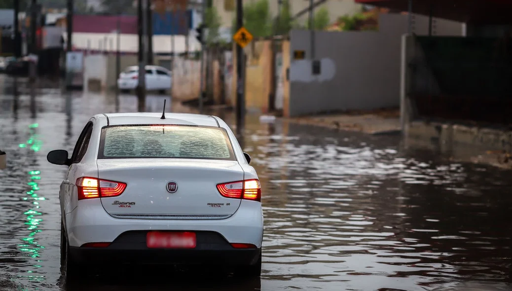 Carro andando em avenida alagada
