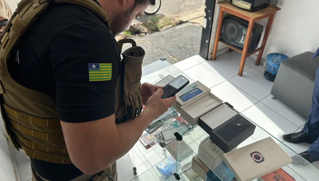 Delegado Filipe Bonavides verificando o número do IMEI do celular