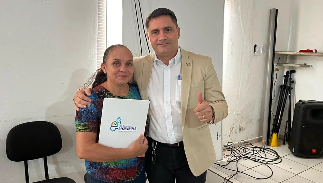 Moradora recebendo o registro de imóvel