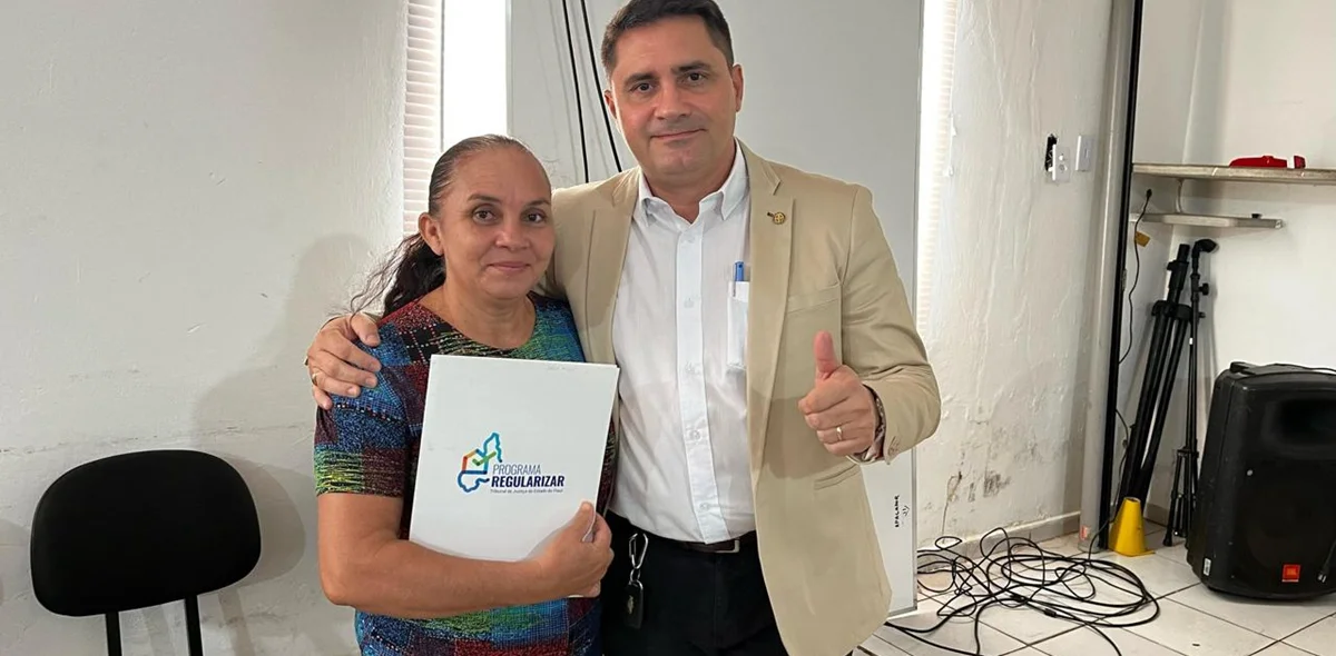 Moradora recebendo o registro de imóvel