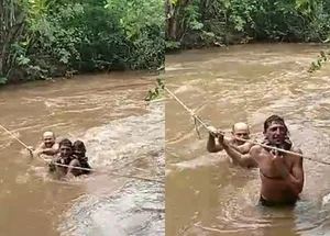 Moradores de Milton Brandão atravessando rio por meio de corda