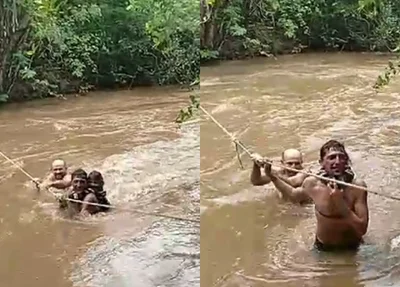 Moradores de Milton Brandão atravessando rio por meio de corda