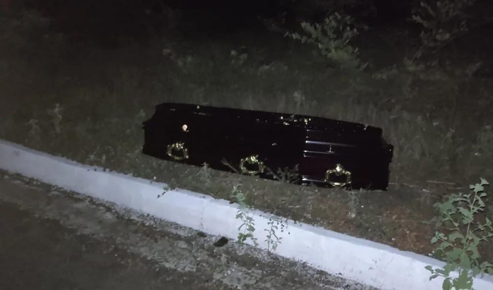 O caixão que estava sendo transportado ficou exposto após a colisão