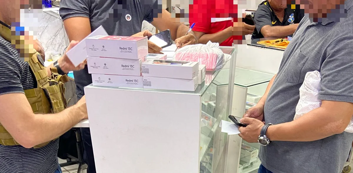 Policiais verificando se os celulares têm restrição de roubo ou furto