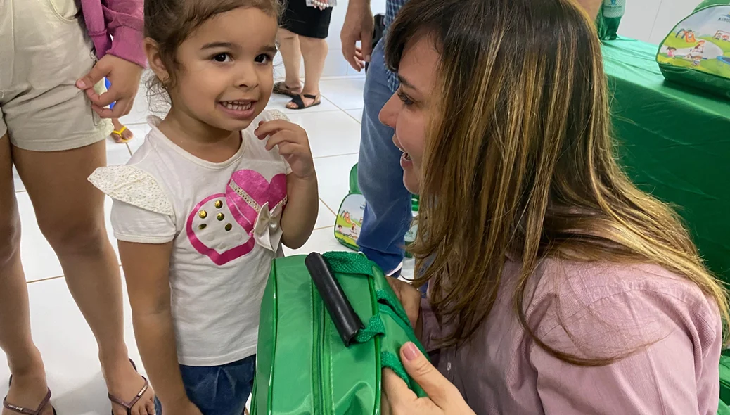 Criança recebendo o kit escolar