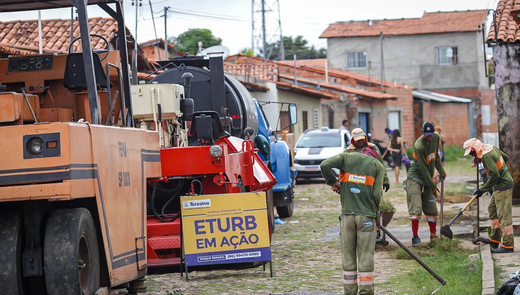 Trabalhadores limpando a rua para receber o asfalto