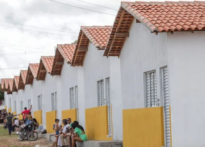 Famílias em frente às novas casas
