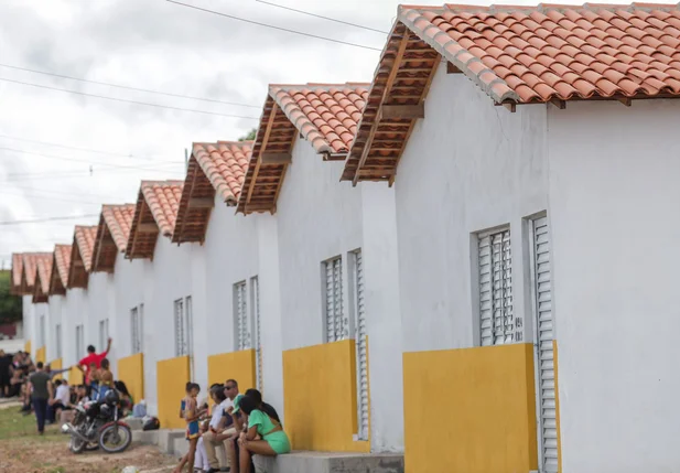 Famílias em frente às novas casas