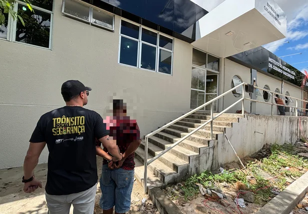 Homem sendo conduzido pelos policiais da Diretoria de Operações de Trânsito da Secretaria de Segurança Pública do Piauí