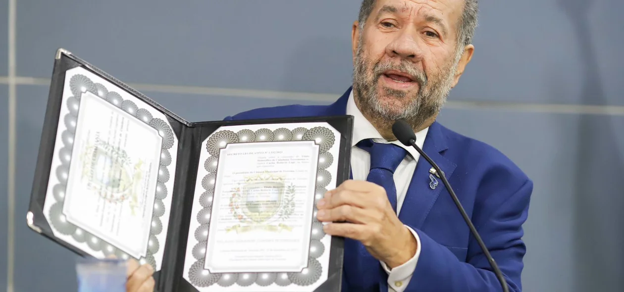 Ministro Carlos Lupi com o título nas mãos