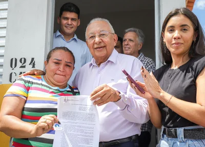 Prefeito Dr. Pessoa entregando documento de posse dos imóveis às famílias