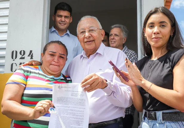 Prefeito Dr. Pessoa entregando documento de posse dos imóveis às famílias