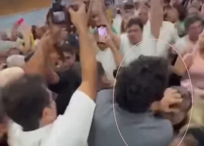 Fotógrafo identificado como Jorge Bastos Moreno puxando cabelo de mulher durante evento em Parnaíba