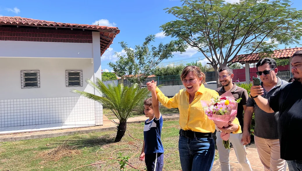 Momento em que a prefeita recebe flores dos alunos