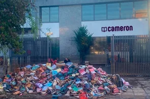Pilha de livros destruídos pelas enchentes, em frente do centro de distribuição da Cameron, em Porto Alegre
