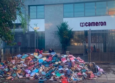 Pilha de livros destruídos pelas enchentes, em frente do centro de distribuição da Cameron, em Porto Alegre