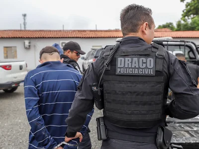 Delegado Charles condizindo um dos presos durante operação