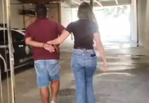 Momento em que acusado é conduzido por policial civil na baixada fluminense