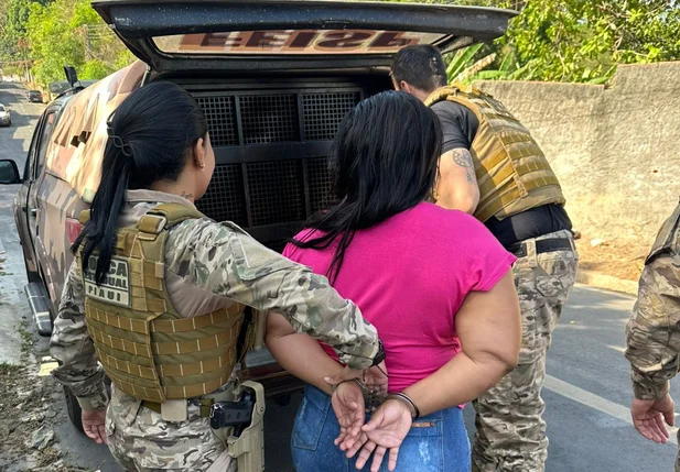 Mulher suspeita de receptação sendo conduzida pela polícia