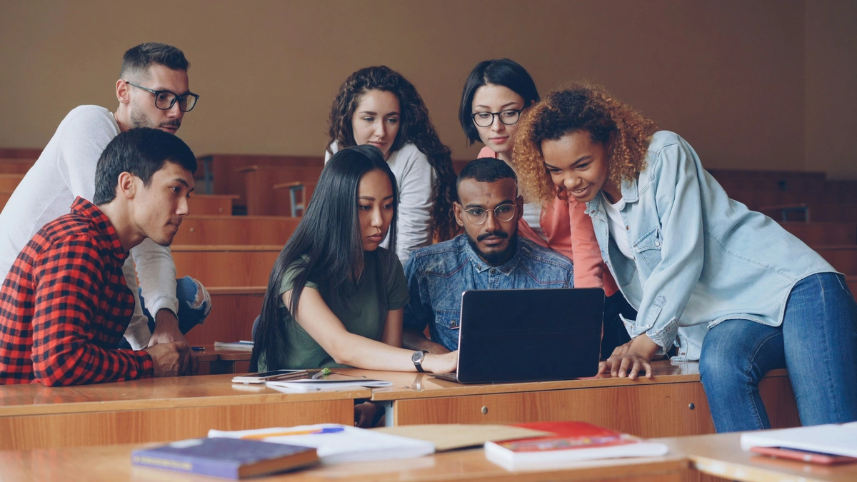 Estudantes reunidos em torno do laptop