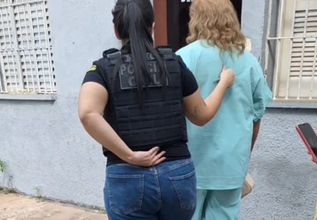 Acusada sendo conduzida pela Polícia Civil