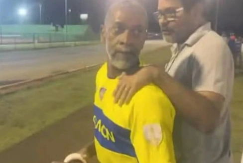 Homem de amarelo, preso enquanto particiapava de partida de futebol amador, por arrastar filha presa em carro no RJ