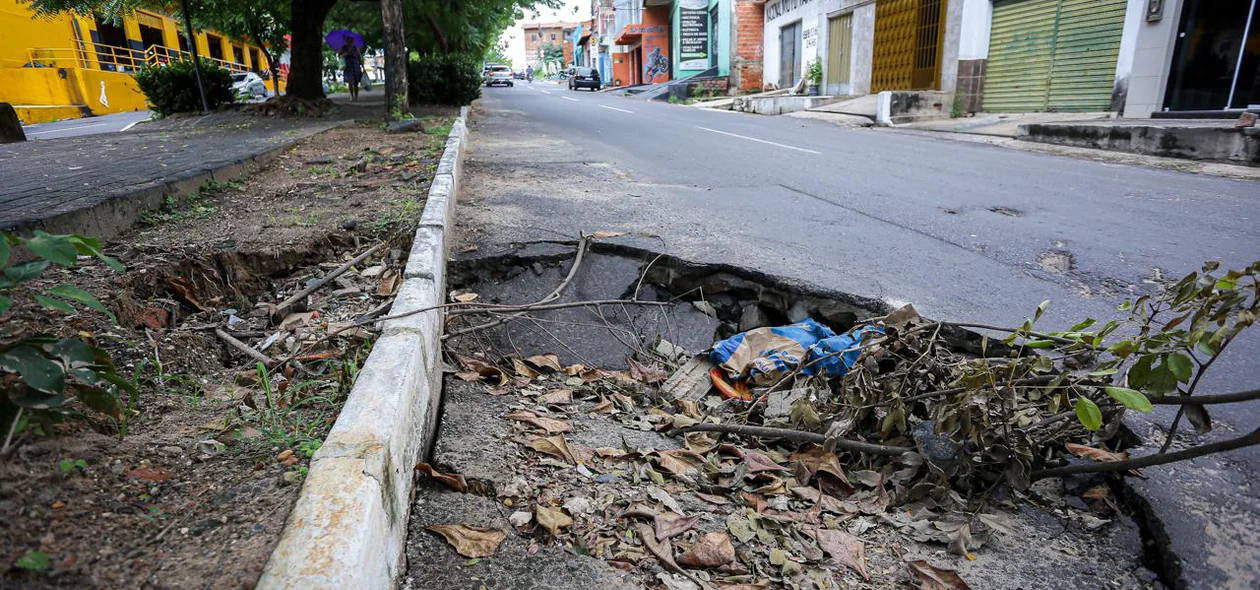 Resíduos acumulam em buraco na rua
