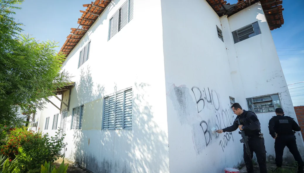 Blocos de apartamento com pichações do Bonde dos 40 sendo apagadas