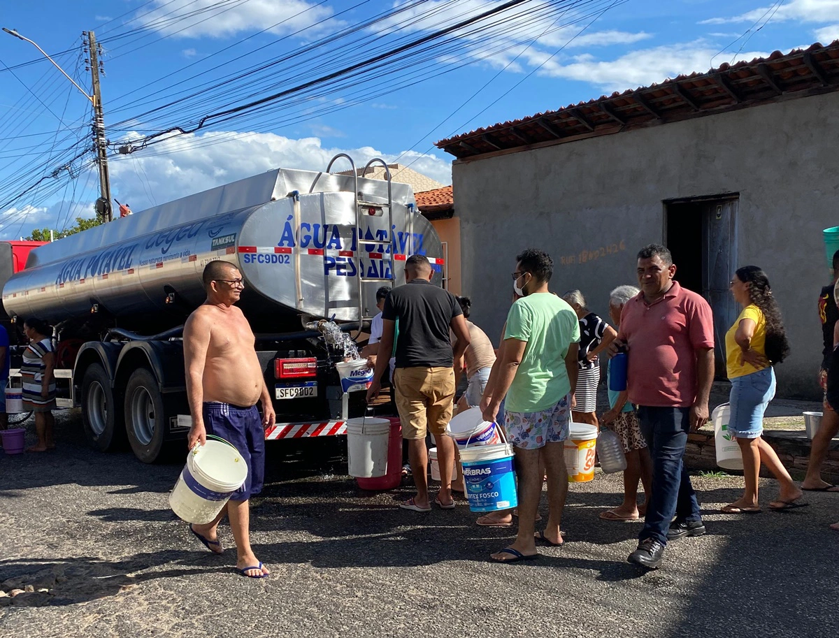 Moradores abastecem baldes em caminhão-pipa
