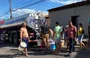 Moradores abastecem baldes em caminhão-pipa
