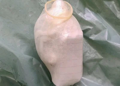 Material armazenado dentro de uma camisinha
